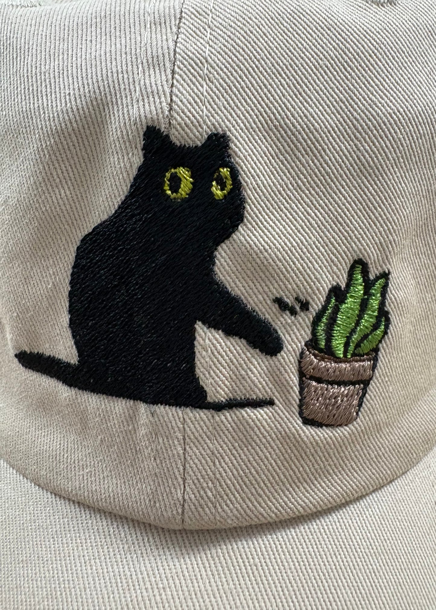 Cat knocking over plant embroidered on ran dad hat