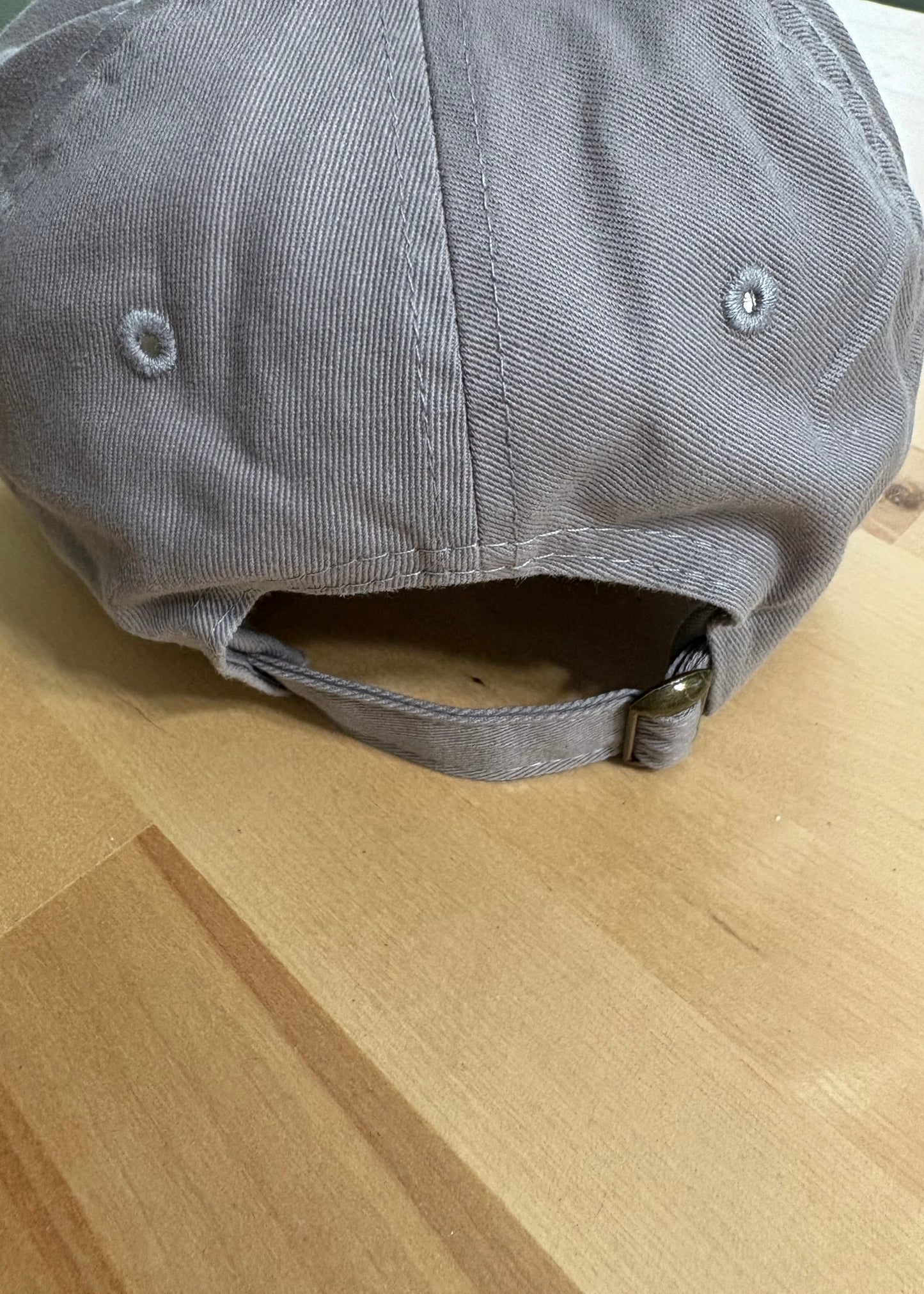 Cat knocking over plant embroidered on light grey dad hat