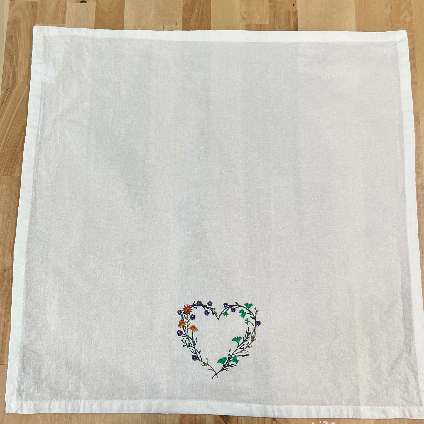 Wildflower heart embroidered on white dinner napkin