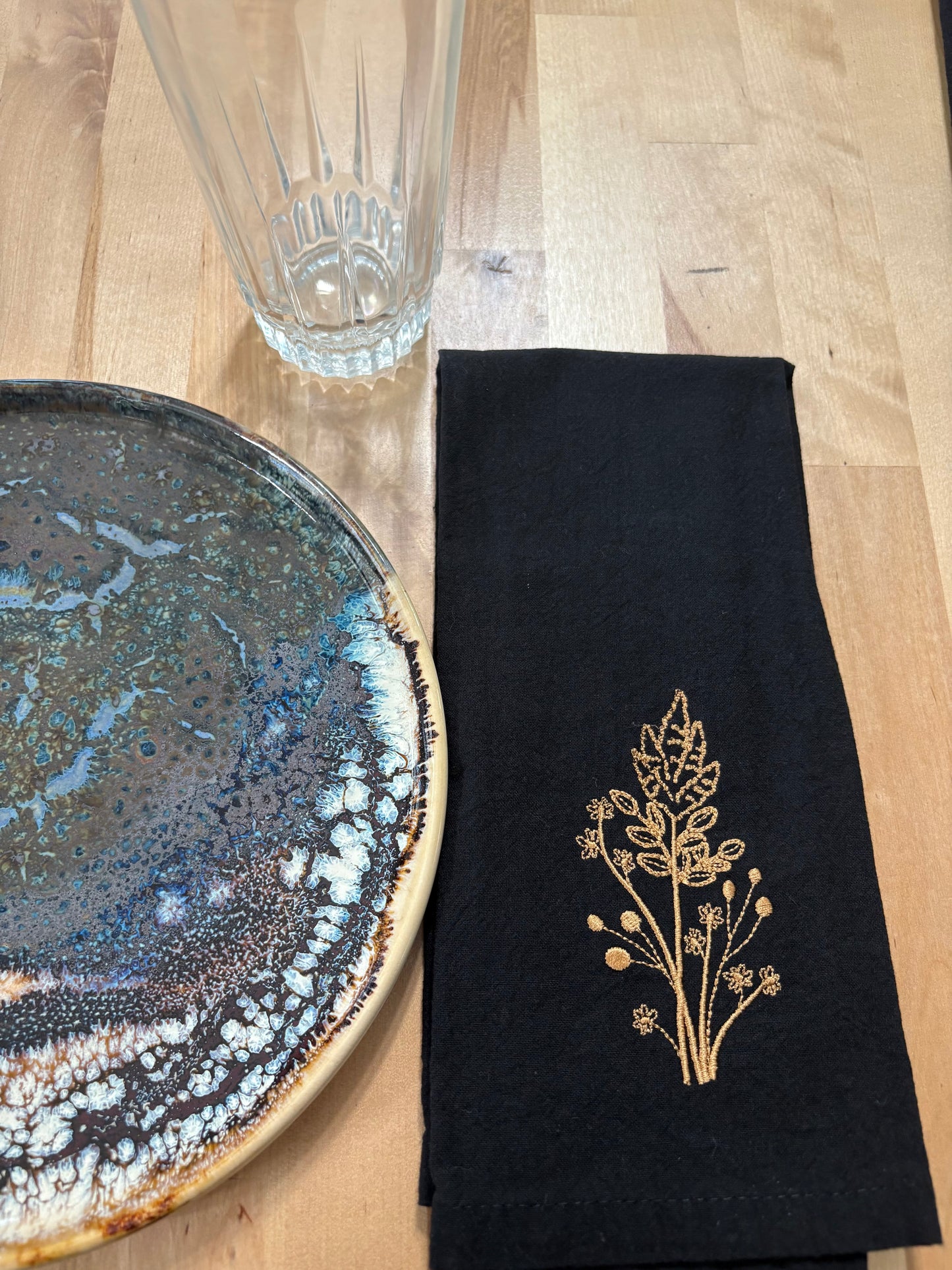 Black cotton napkin with gold embroidered golden rod
