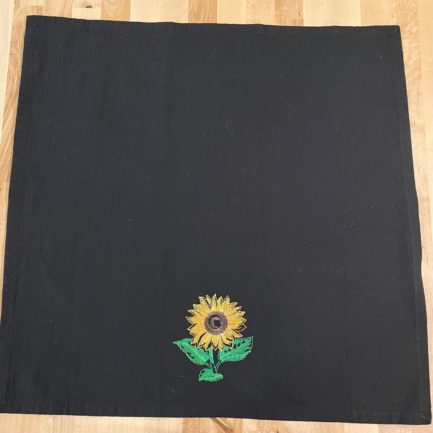 Sunflower embroidered on black dinner napkin