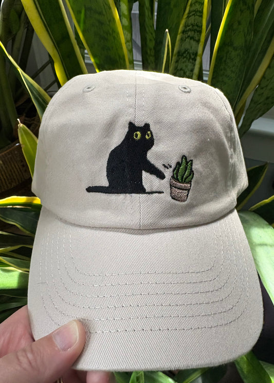 Cat knocking over plant embroidered on ran dad hat