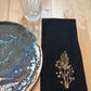 Black cotton napkin with gold embroidered golden rod