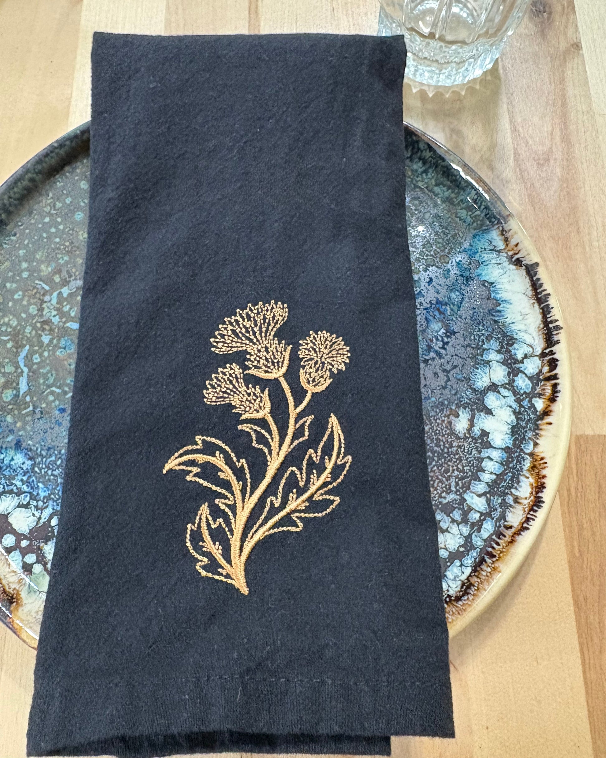 Black cotton napkin with gold embroidered thistle