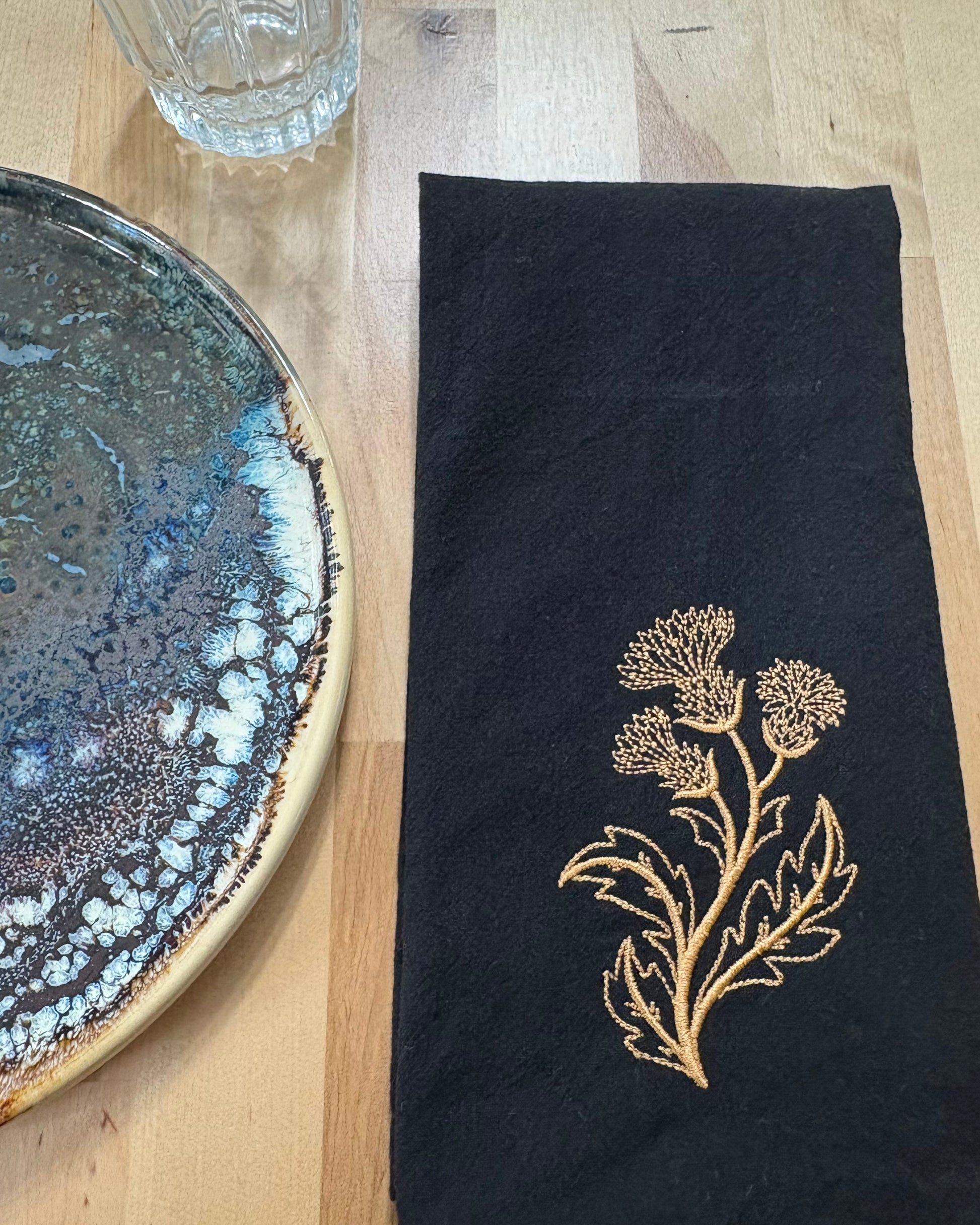 Black cotton napkin with gold embroidered thistle
