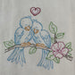 Close up of love birds embroidered on a flour sack towel