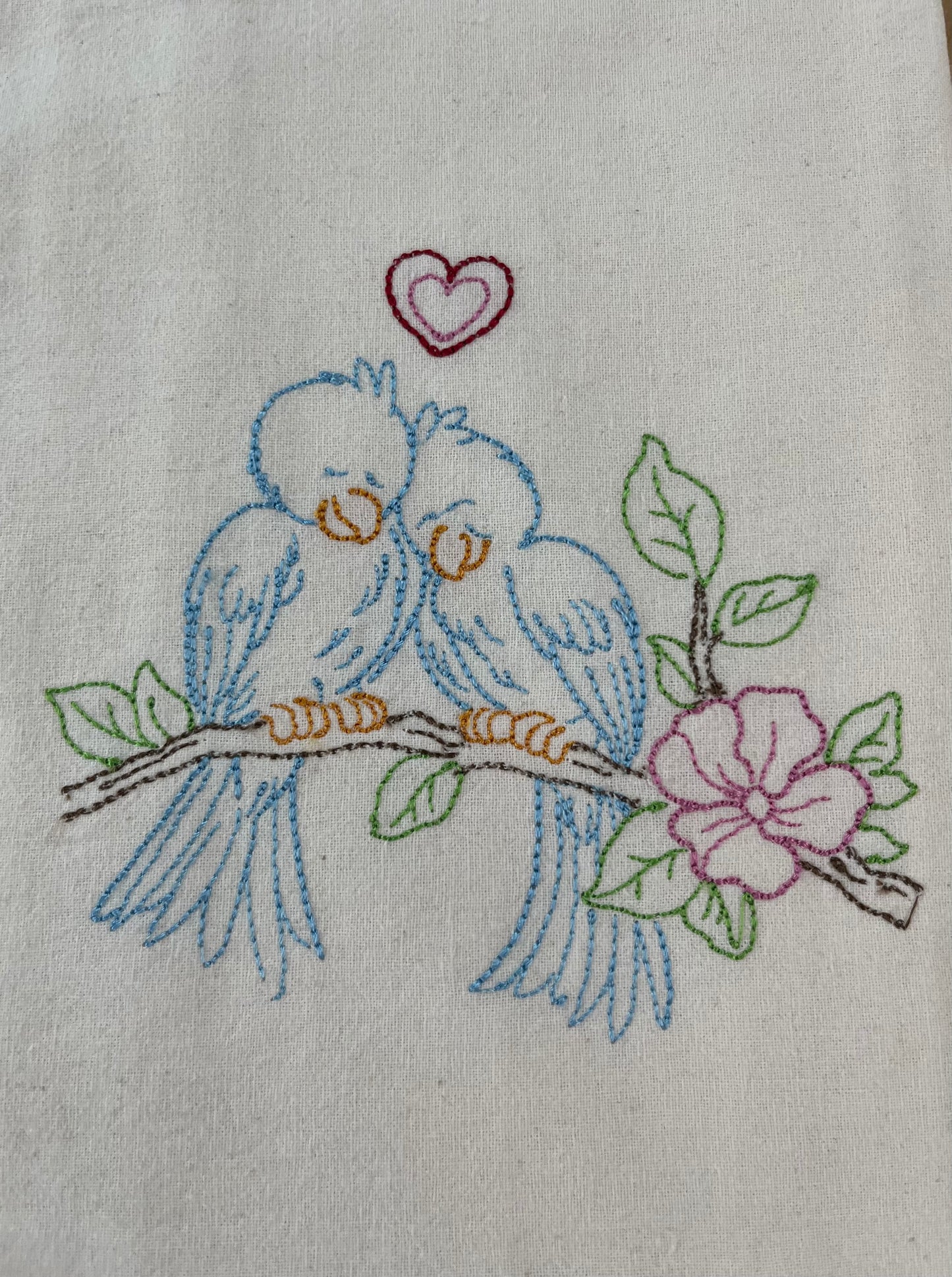 Close up of love birds embroidered on a flour sack towel