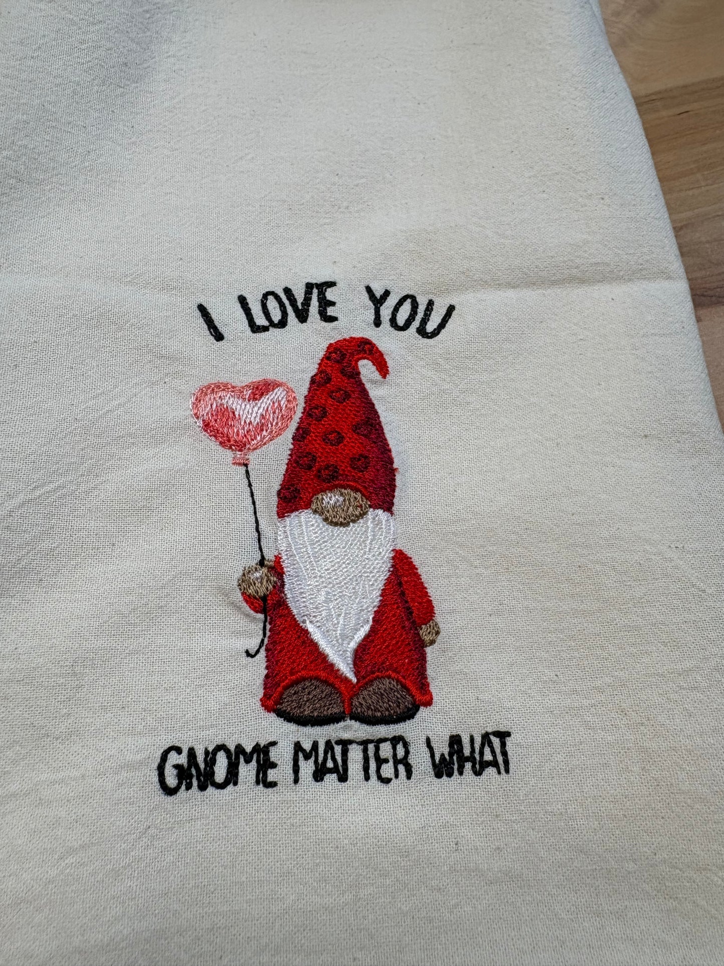 Embroidered towel with a gnome design and text on a white background