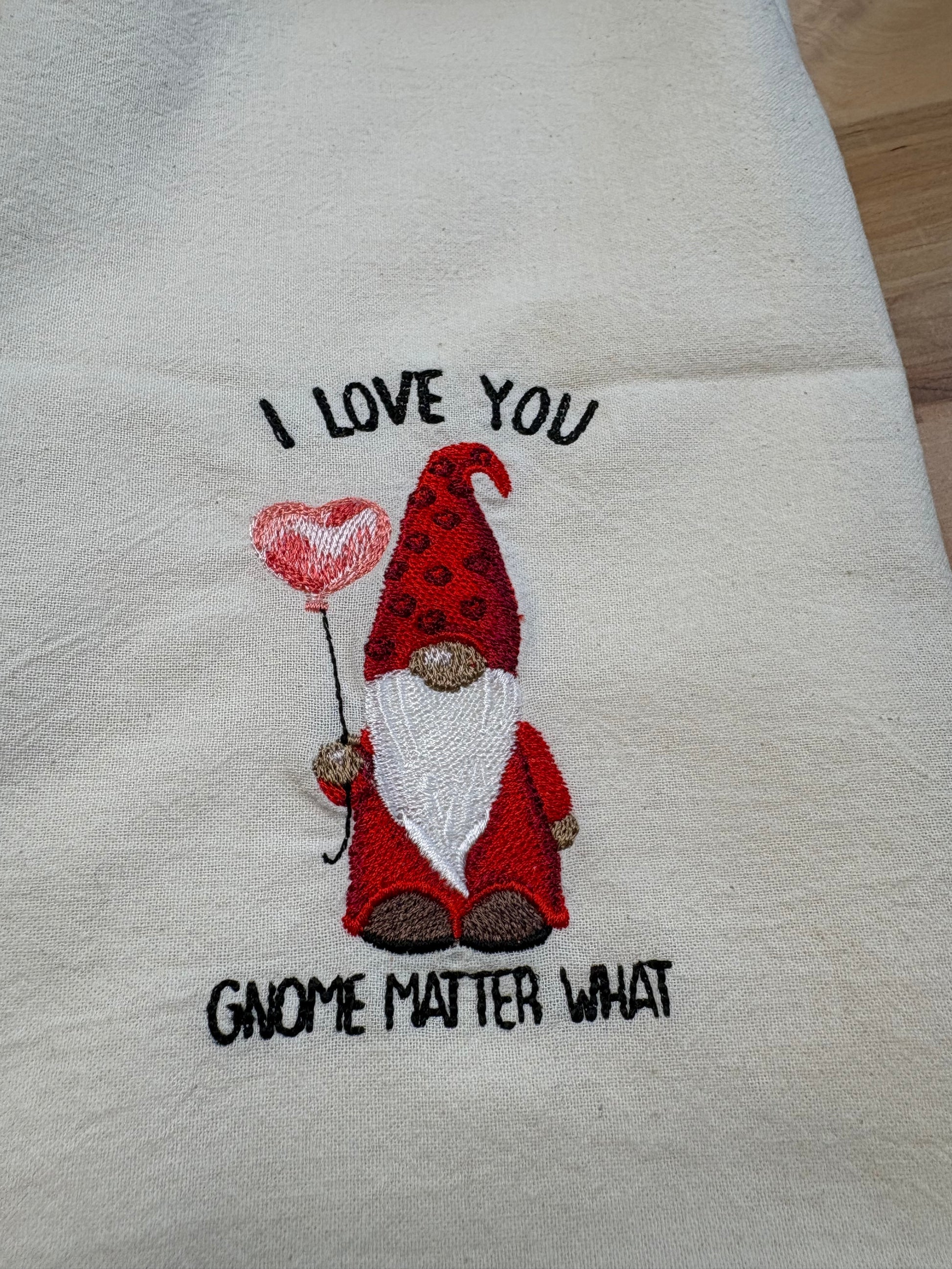 Embroidered towel with a gnome design and text on a white background