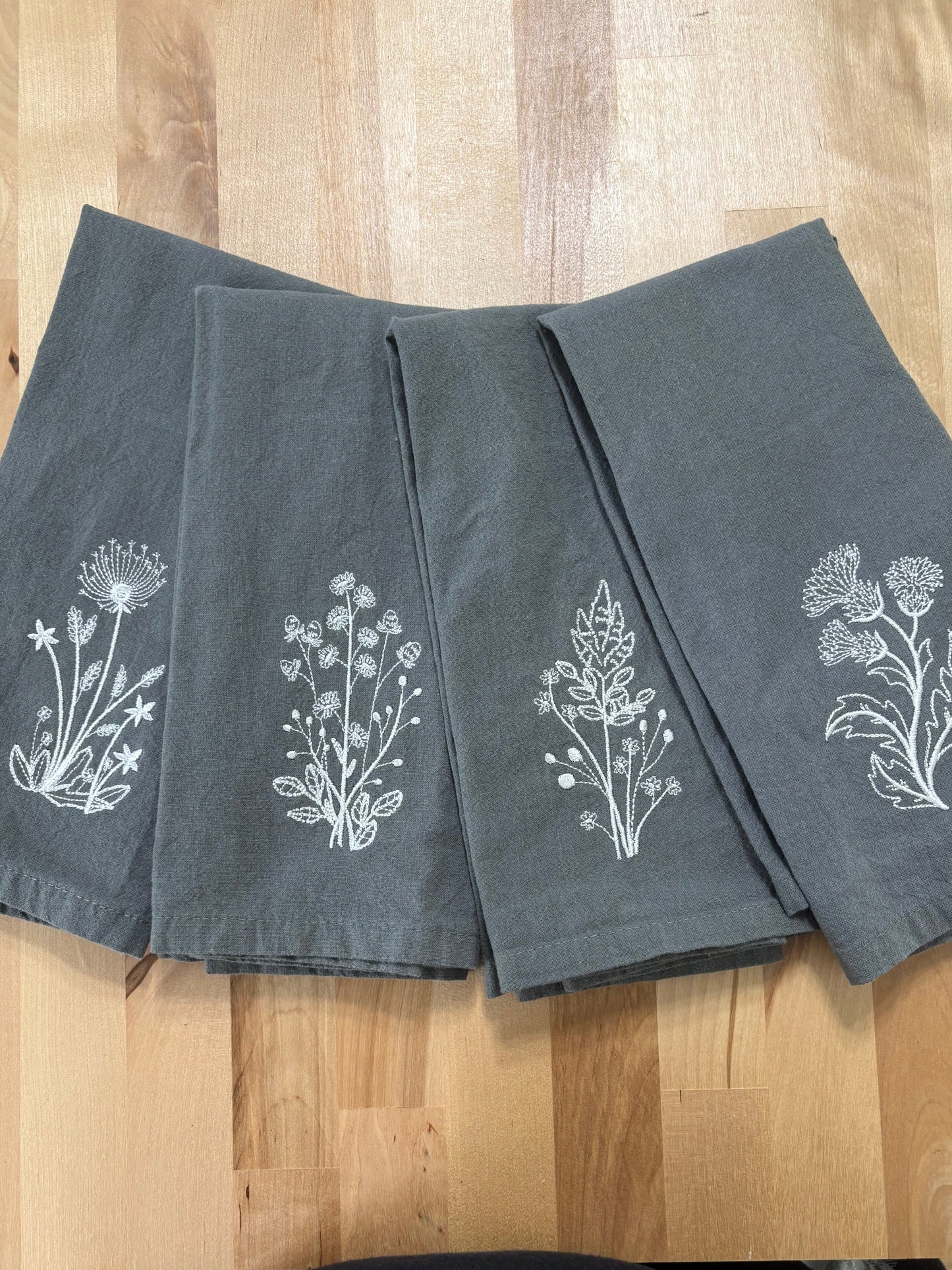 et of grey napkins embroidered with white stems