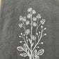 White daisies embroidered on grey napkin