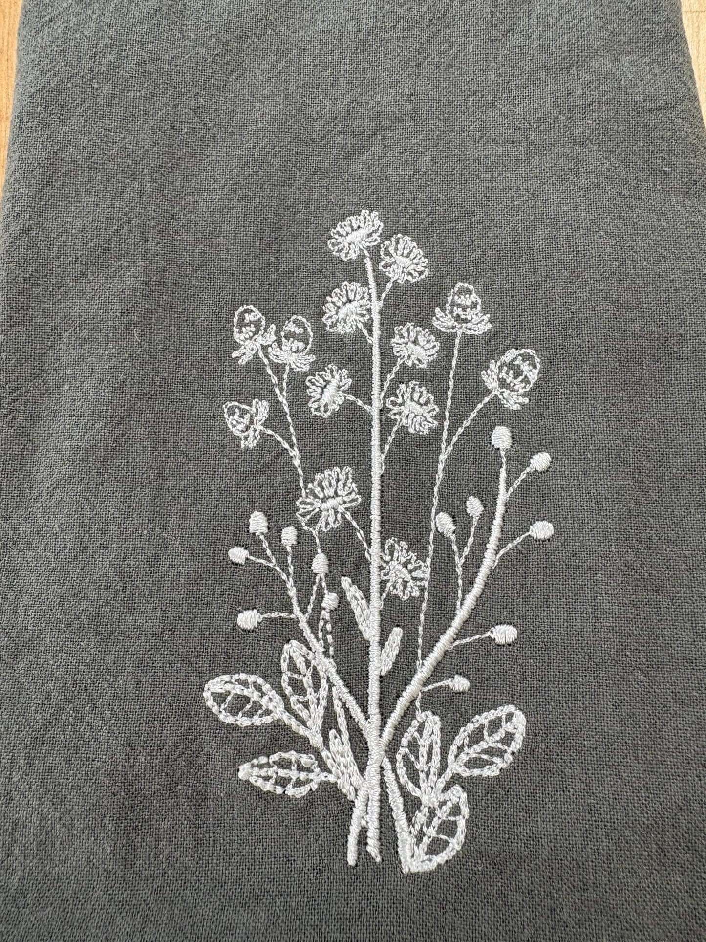 White daisies embroidered on grey napkin