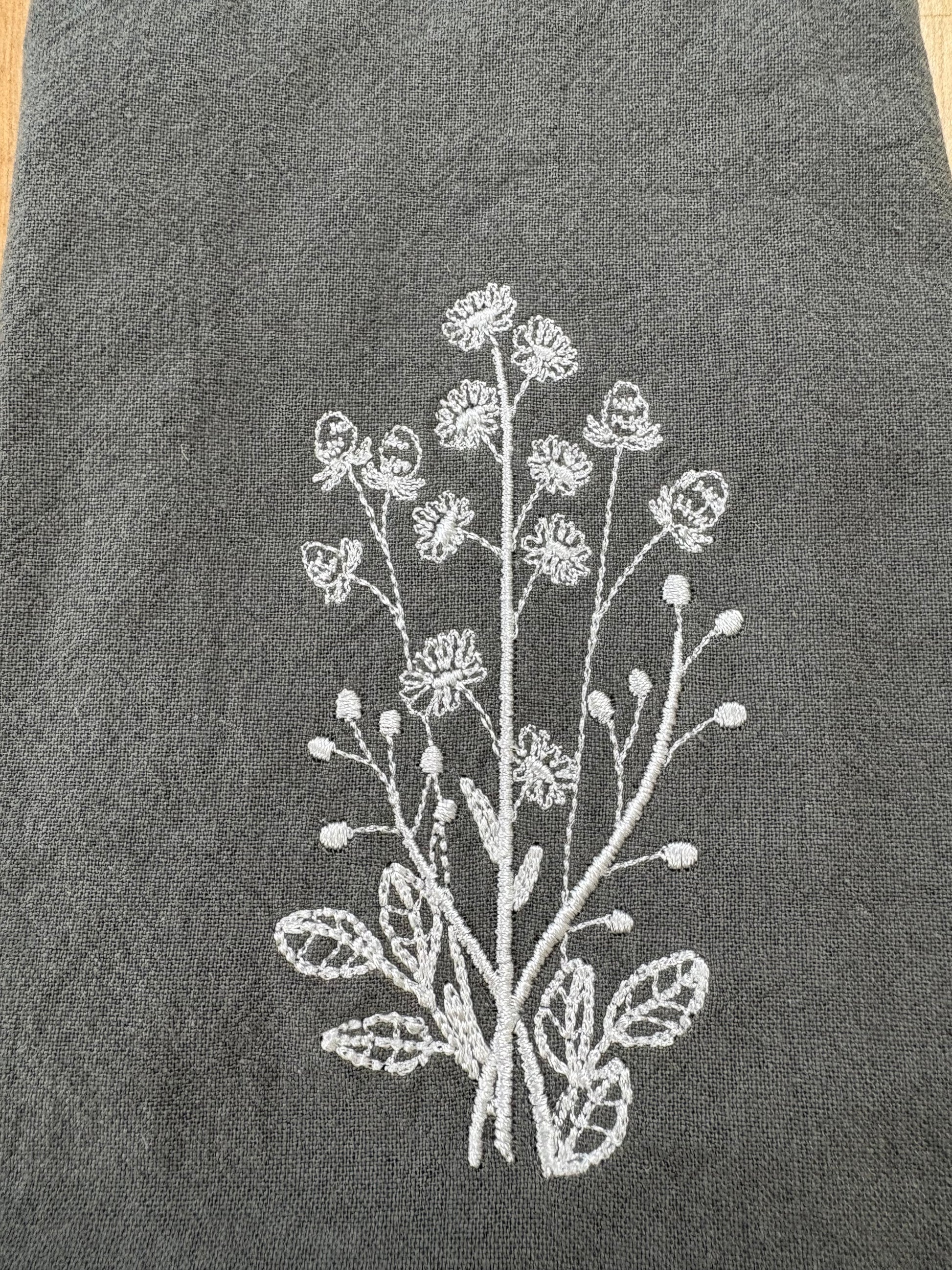 White daisies embroidered on grey napkin