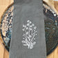 White daisies embroidered on grey napkin