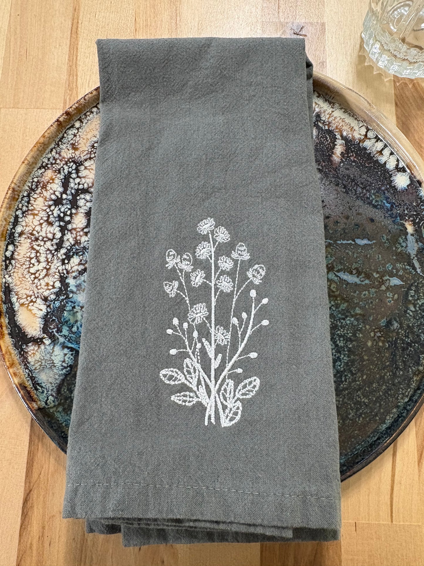 White daisies embroidered on grey napkin