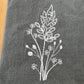 White goldenrod embroidered on grey napkin