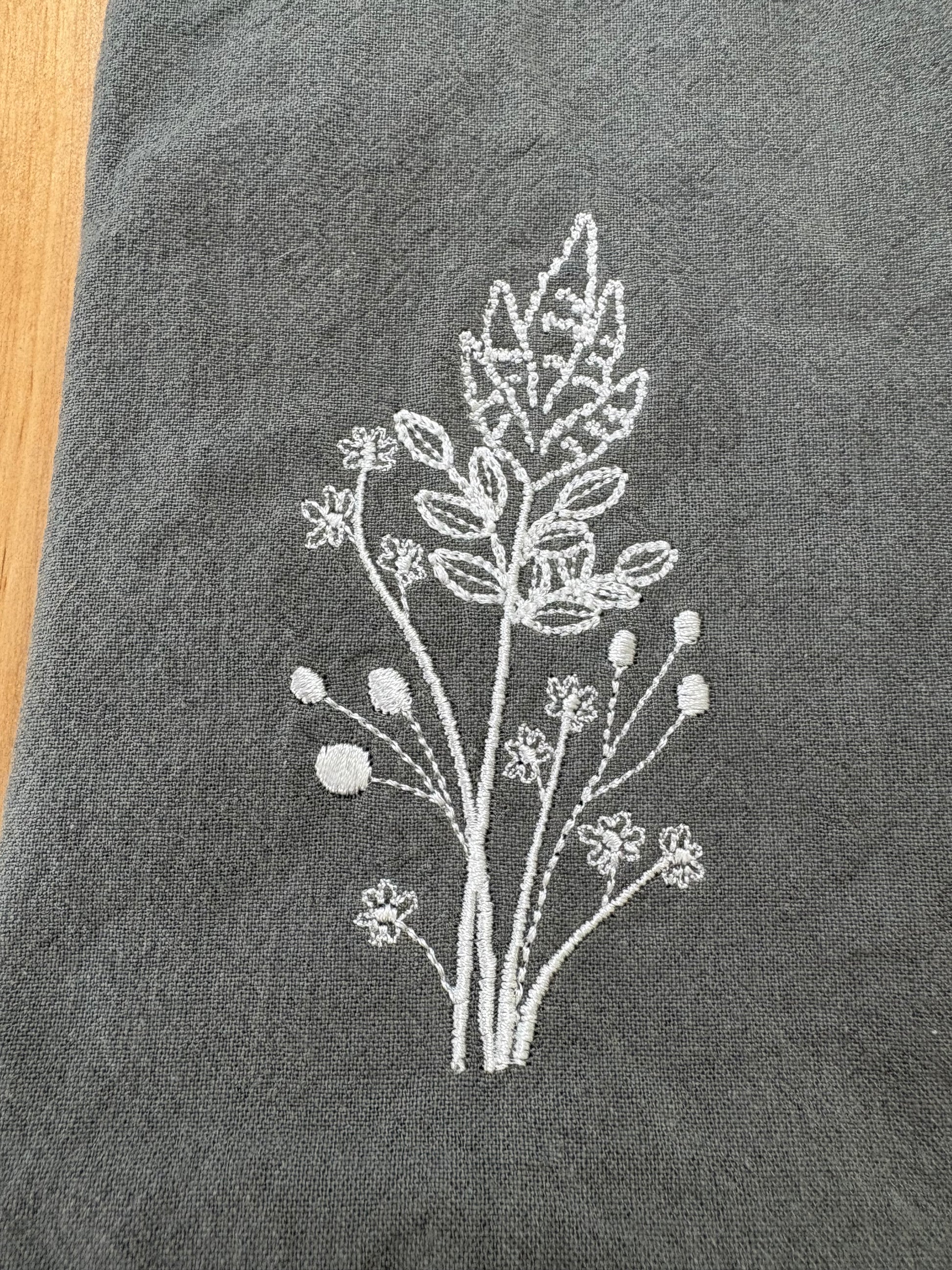 White goldenrod embroidered on grey napkin
