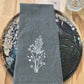 White goldenrod embroidered on grey napkin
