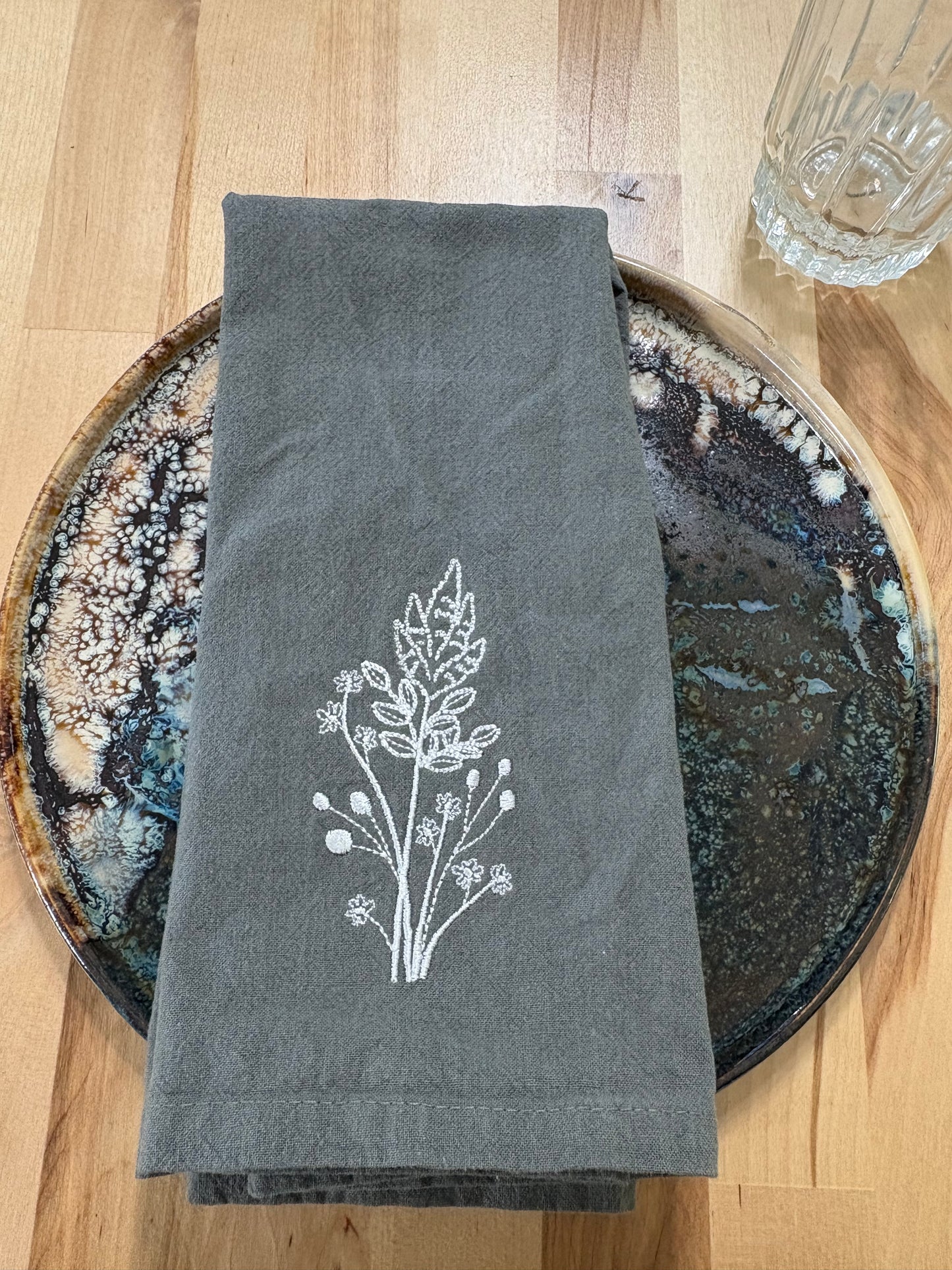 White goldenrod embroidered on grey napkin