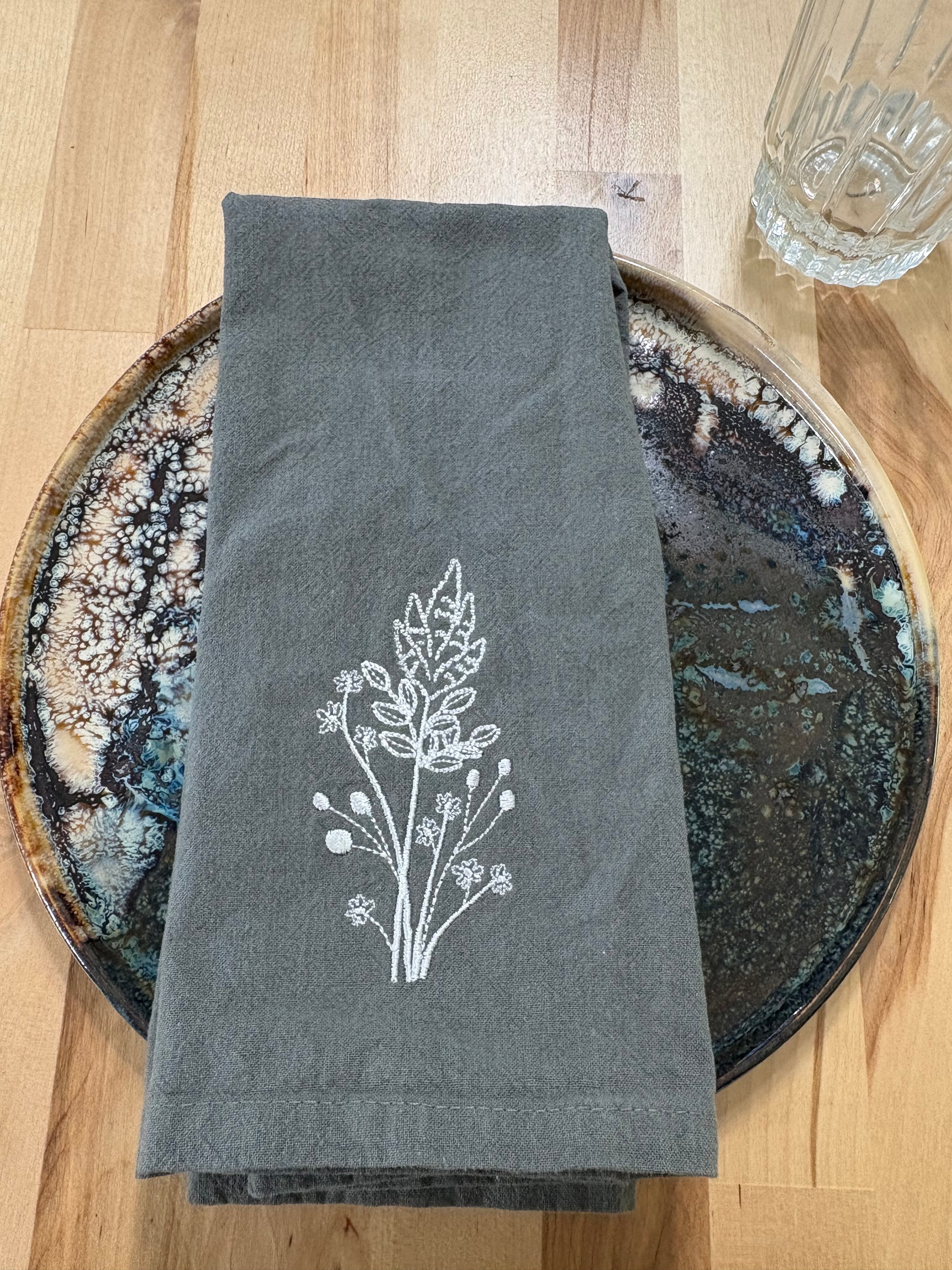 White goldenrod embroidered on grey napkin