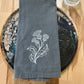 White thistle embroidered on grey napkin