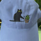 Cat knocking over plant embroidered on light purple cotton dad hat