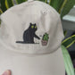 Cat knocking over plant embroidered on ran dad hat
