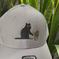 Cat knocking over plant embroidered on light grey Otto trucker hat